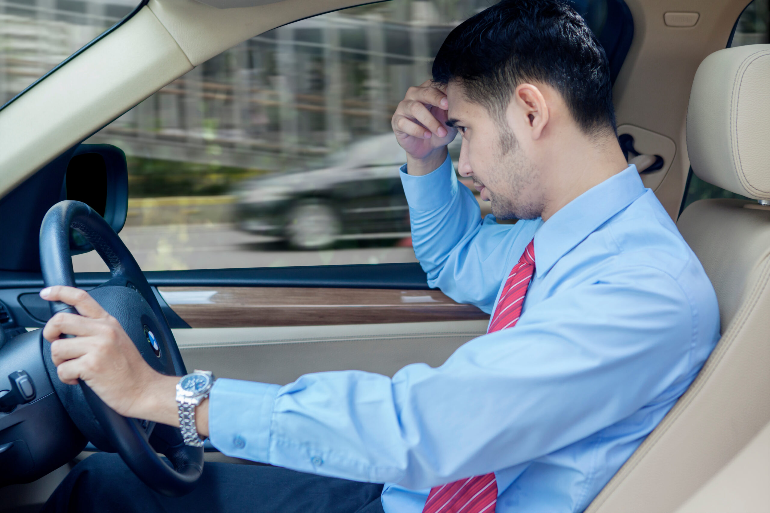 Portrait of a young man with disabilities driving a car while thinking about his forgotten placard