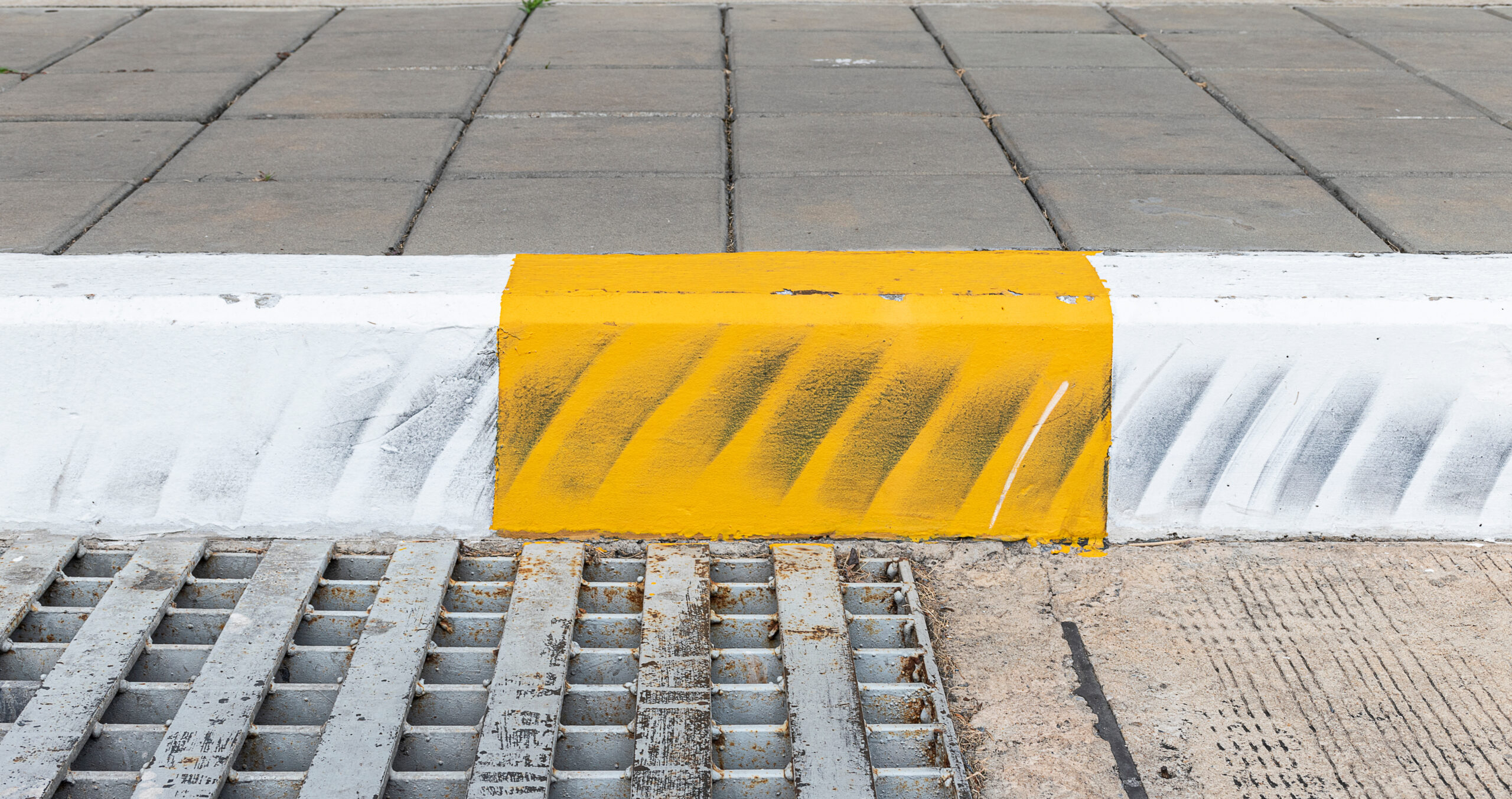 Yellow And White Color Curb Stained With Tires